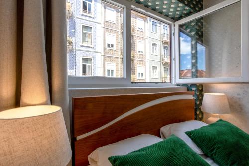 a bedroom with a window and a bed with a green pillow at Lisbon Poets Inn in Lisbon
