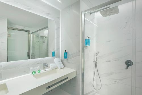 a white bathroom with a sink and a shower at Gran Hotel Las Fuentes in Alcossebre