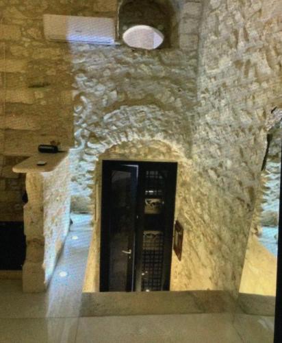 a building with a stone wall with a black door at Appartamento Centrale Apeneste in Vieste