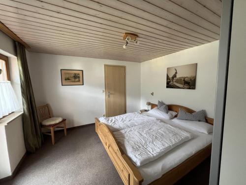 a bedroom with a large bed with a wooden ceiling at Ferienwohnung 1 Am Krepbach in Grainau