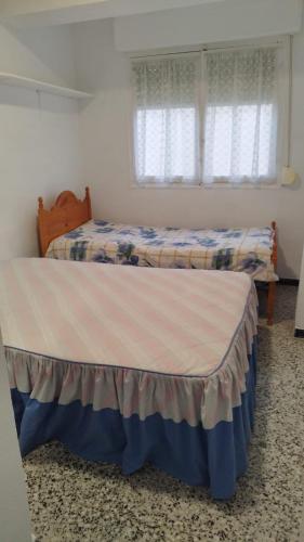 a bedroom with two beds and a window at Playa a dos pasos in Santa Pola