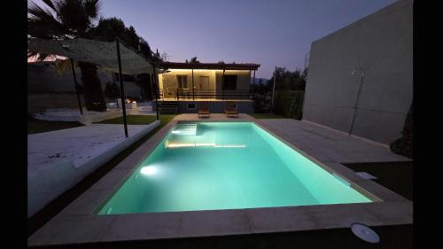 a swimming pool in front of a house at Dolce Far Niente Greece in Agioi Theodoroi