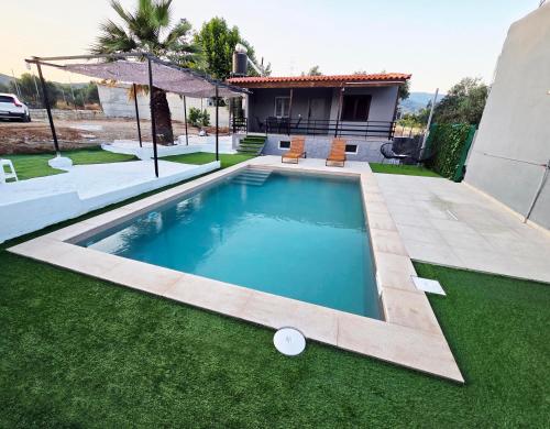 a swimming pool in the yard of a house at Dolce Far Niente Greece in Agioi Theodoroi