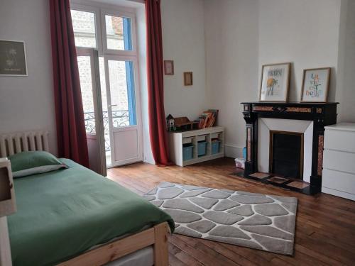 a bedroom with a bed and a fireplace at Maison familiale en centre bourg in Ahun