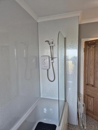 a bathroom with a shower and a tub at Beautiful 2-Bed semi rural cottage enclosed garden in Drummore