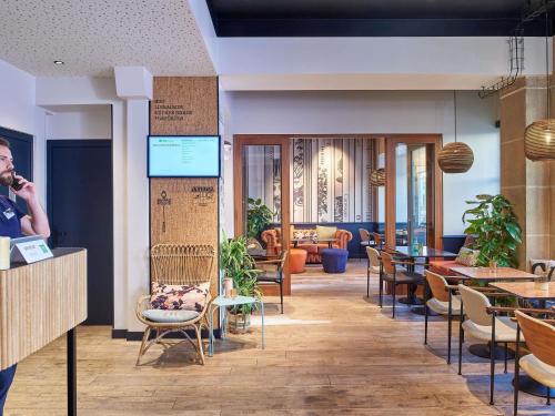 a man talking on a cell phone in a restaurant at Ibis Styles Hotel Paris Gare de Lyon Bastille in Paris