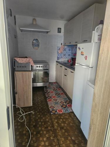 a small kitchen with a stove and a refrigerator at Villetta maddalena in Lecce