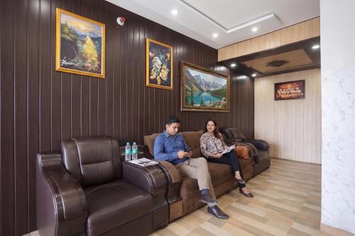 a man and woman sitting on a couch in a waiting room at FabHotel The Max in Lucknow