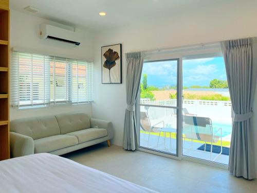 a living room with a couch and a large window at Villa Tara - Sea view 5Br Rawai in Ban Saiyuan (1)
