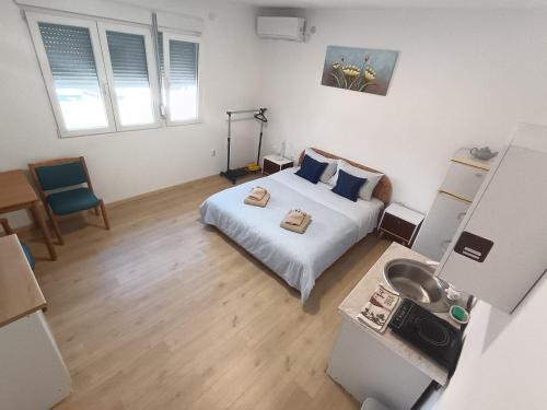 a bedroom with a bed and a sink in it at Komforna Soba U Centru #3 in Mladenovac