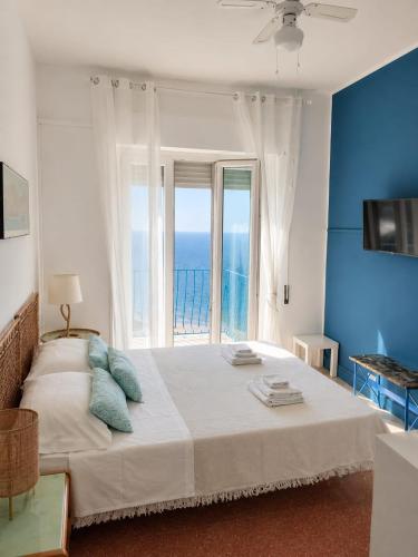 a bedroom with a large bed with a view of the ocean at CasaAzul in Sperlonga