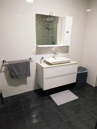 a white bathroom with a sink and a mirror at Apartman Vila Vita in Čapljina