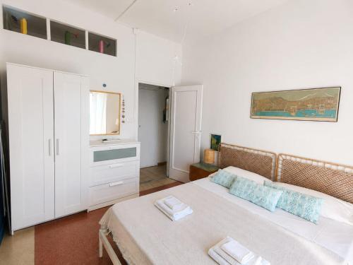 a white bedroom with a bed and a bathroom at CasaAzul in Sperlonga