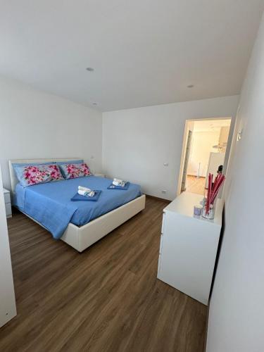 a bedroom with a bed and a wooden floor at Villa Rosmarino sea view in Capraia