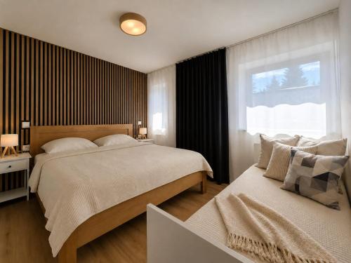 a bedroom with two beds and a window at Javorná - Aura a Nord in Čachrov