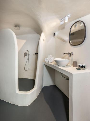 a bathroom with a sink and a mirror at Elios Cave Suites in Oia