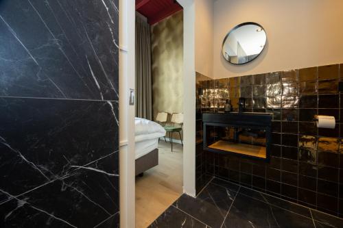 a bathroom with a fireplace and a mirror at Groupaccommodation with 10 bedrooms in Scherpenzeel