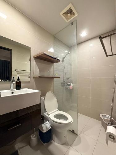 a bathroom with a toilet and a sink and a mirror at Ocean View Escape at The Mactan Newtown in Punta Engaño