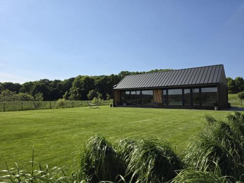 a modern house with a large green field at Morze Dębina in Debina