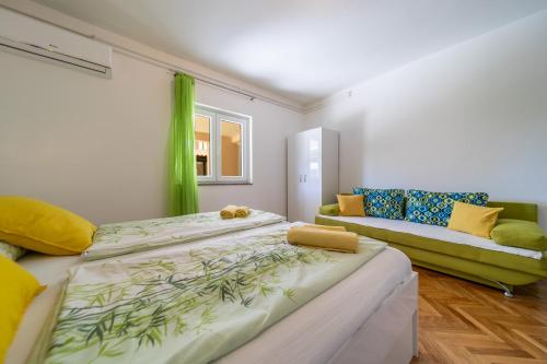 a bedroom with two beds and a couch in it at Rooms and Apartments Lidija in Lopar