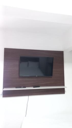 a flat screen tv sitting on a stand at Pousada e hostel Italia in São Luís