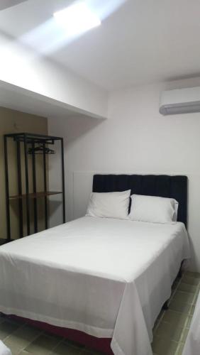 a bedroom with a large white bed with white pillows at Pousada e hostel Italia in São Luís