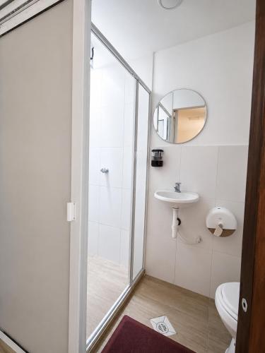 a bathroom with a shower and a toilet and a sink at KOKOA GARDEN INN in San Vicente de Chucurí
