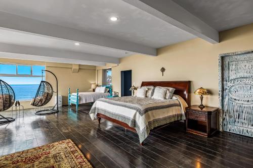 a large bedroom with a bed and a couch at Tropical Retreat with Ocean Views - Steps from the sand with alfresco dining in Rosarito