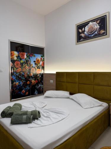 a bed with a stuffed teddy bear laying on it at AA Boutique Hotel in Shkodër