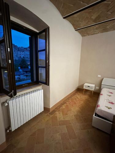 a small room with a bed and a window at Il Nido in Anghiari