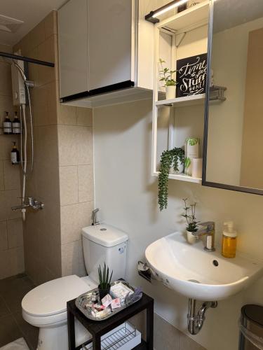 a bathroom with a white toilet and a sink at Maison Angela Suites in Biñan