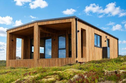 a wooden house on top of a hill at Blue View Cabins in Reykholt