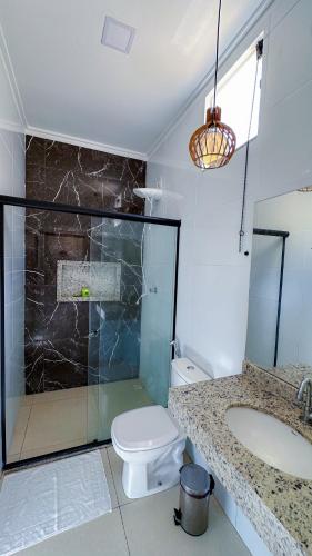 a bathroom with a shower and a toilet and a sink at Hotel e Restaurante Os Sertões in Canudos