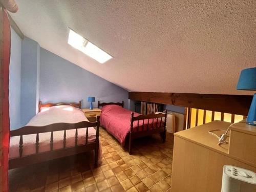 a bedroom with a bunk bed and a desk with a bed sqor at Bret in Valras-Plage