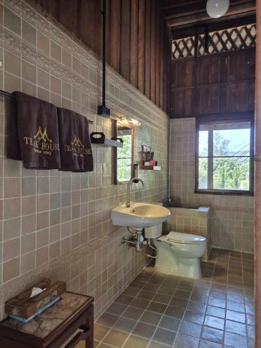 a bathroom with a toilet and a sink at Teak House Homestay II in Ban Thung Satong