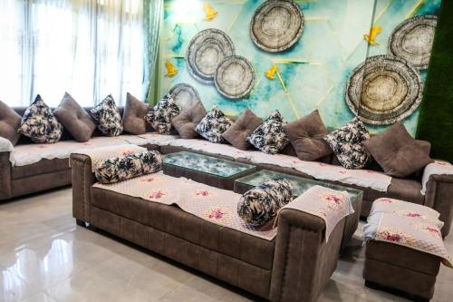 a living room with couches and pillows at Daisy Homestay Dirang in Dirang Dzong