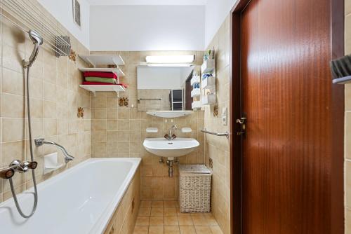 a bathroom with a bath tub and a sink at Riverview Apartment - Bad Aussee in Bad Aussee