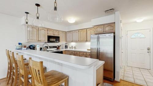 a kitchen with wooden cabinets and a stainless steel refrigerator at Salt Pond --- 38435 Mainsail Dr #9 in Bethany Beach