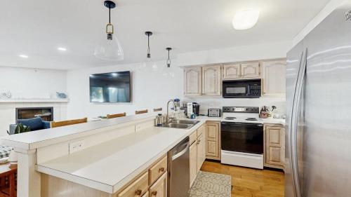 a kitchen with white cabinets and a stainless steel refrigerator at Salt Pond --- 38435 Mainsail Dr #9 in Bethany Beach