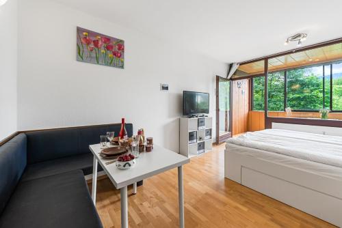 a room with a bed and a table and a couch at Riverview Apartment - Bad Aussee in Bad Aussee