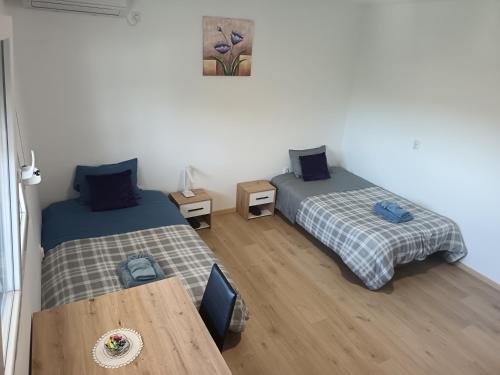 a room with two beds and a wooden table at Soba Za Odmor # in Mladenovac