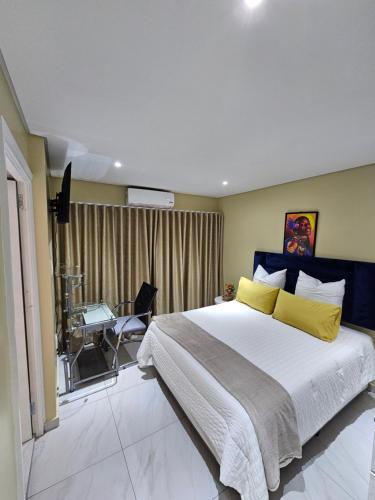 a bedroom with a large bed and a desk at Posimuma in Centurion