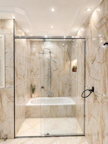 a bathroom with a shower and a tub at Marquis Pyramids Hotel in Cairo