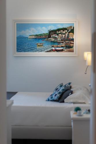 a painting hanging on a wall above a bed at Villa Emanuel in Sant'Agnello