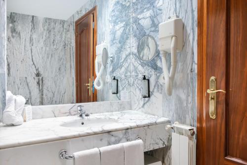 a bathroom with a sink and a mirror at Checkin Basic León Norte in León