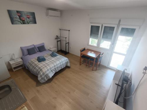 a bedroom with a bed and a table in it at Udobna Soba Sa Prelepim Pogledom #4 in Mladenovac