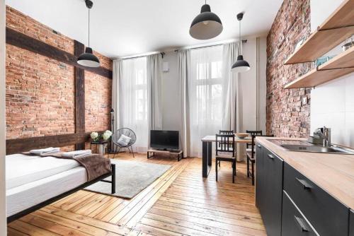 a kitchen and living room with a brick wall at MARGI Igram - Martini - Absynth Apartments LARGE & COMFY in Szczecin