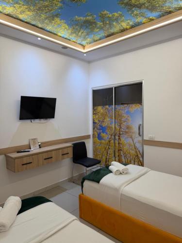 a hotel room with two beds and a tv on a ceiling at AA Boutique Hotel in Shkodër