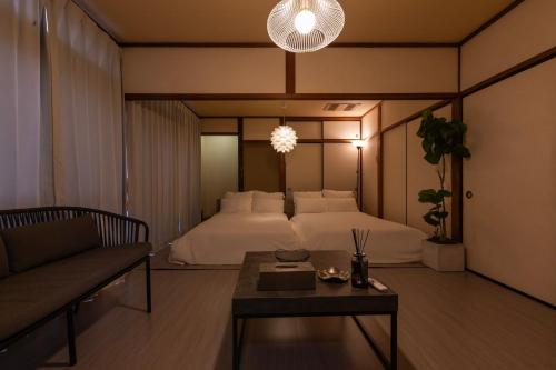 a bedroom with a bed and a couch and a table at gently stay Nagoya in Nagoya
