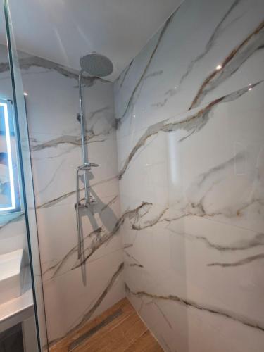a bathroom with marble walls and a shower at Falirala Central in Faliraki